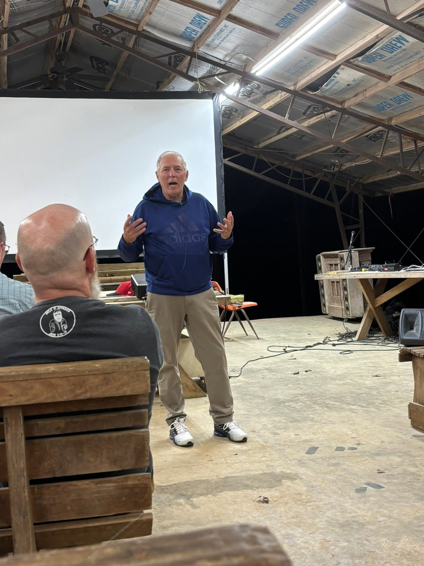 An evening speaker preaching under the pavilion lights