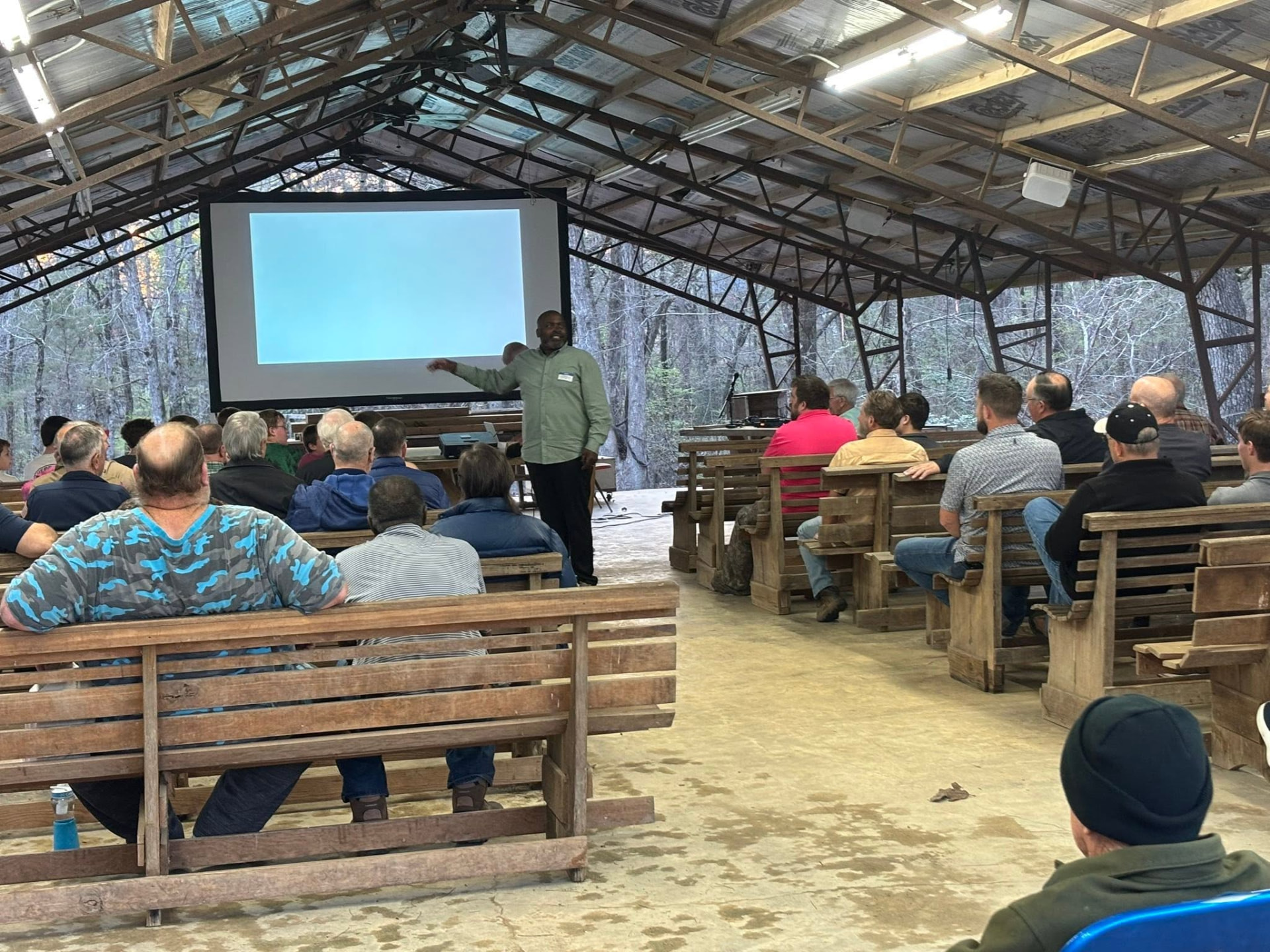 A speaker teaching from the screen at the front of the pavilion