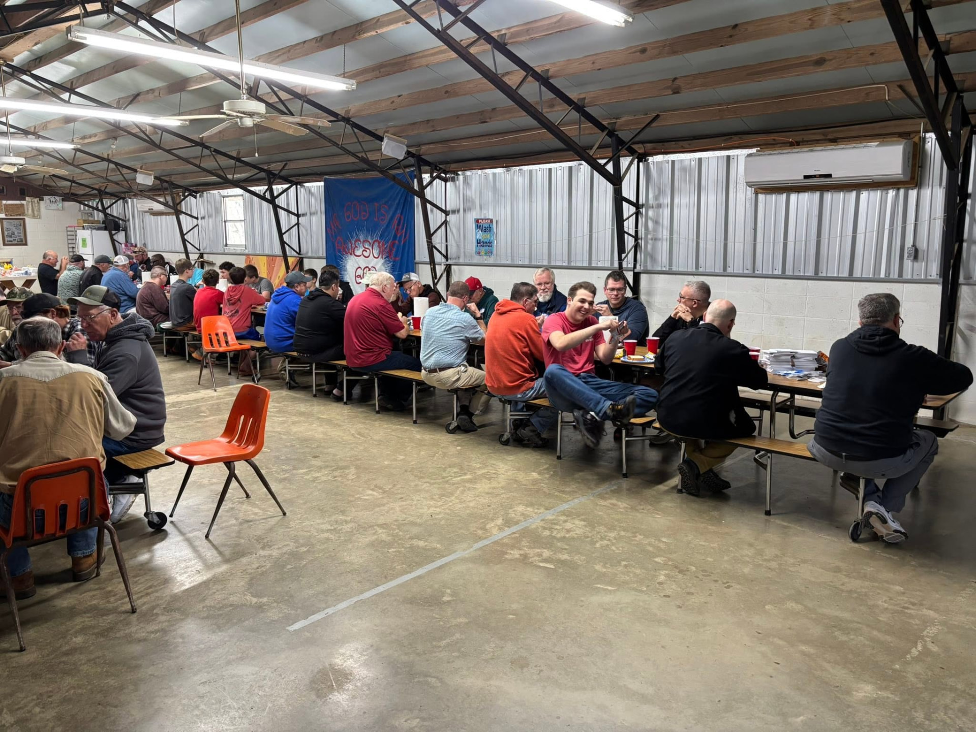 Men visiting over a meal in the camp mess hall