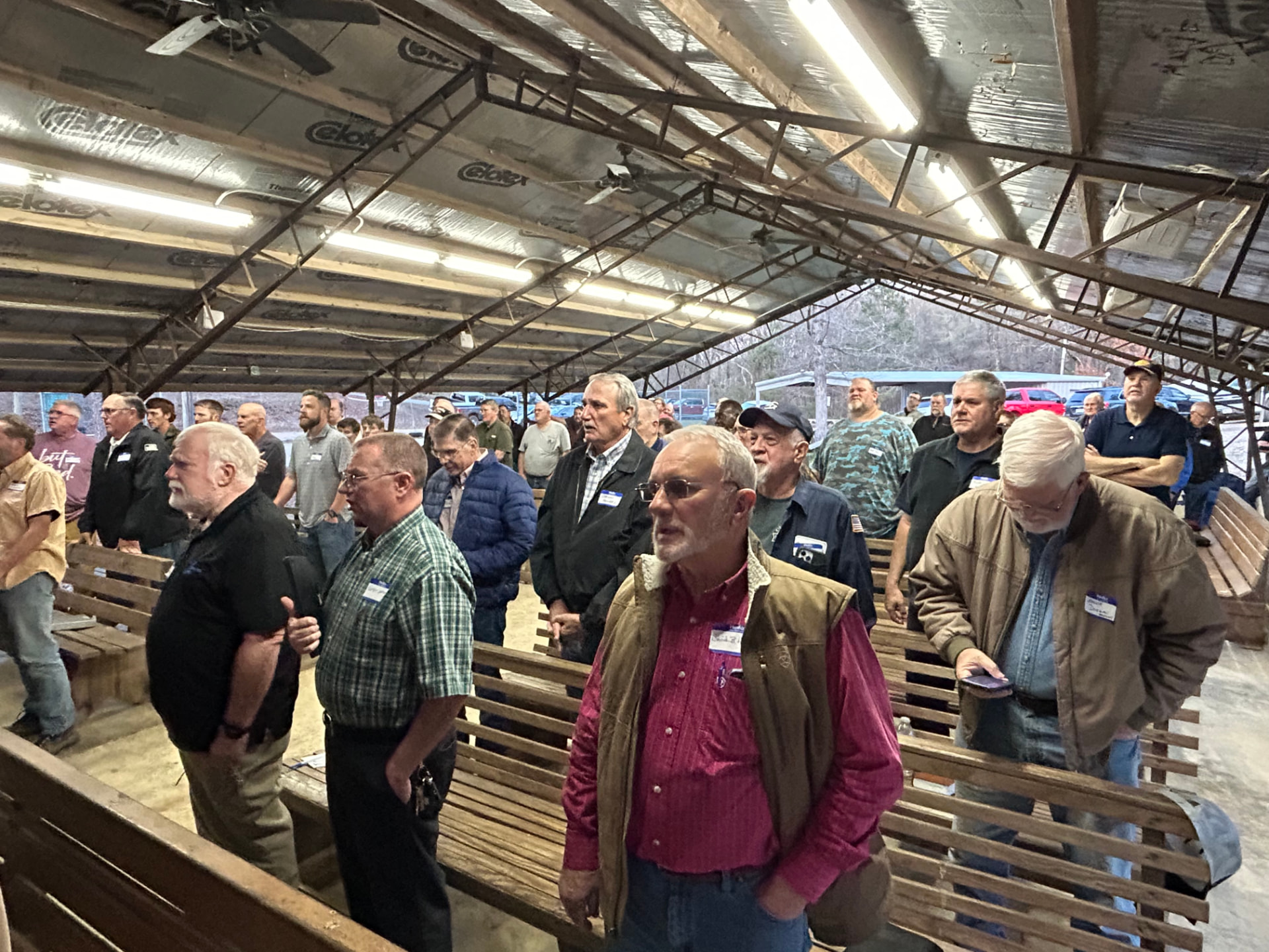Men standing together during singing in the open-air pavilion