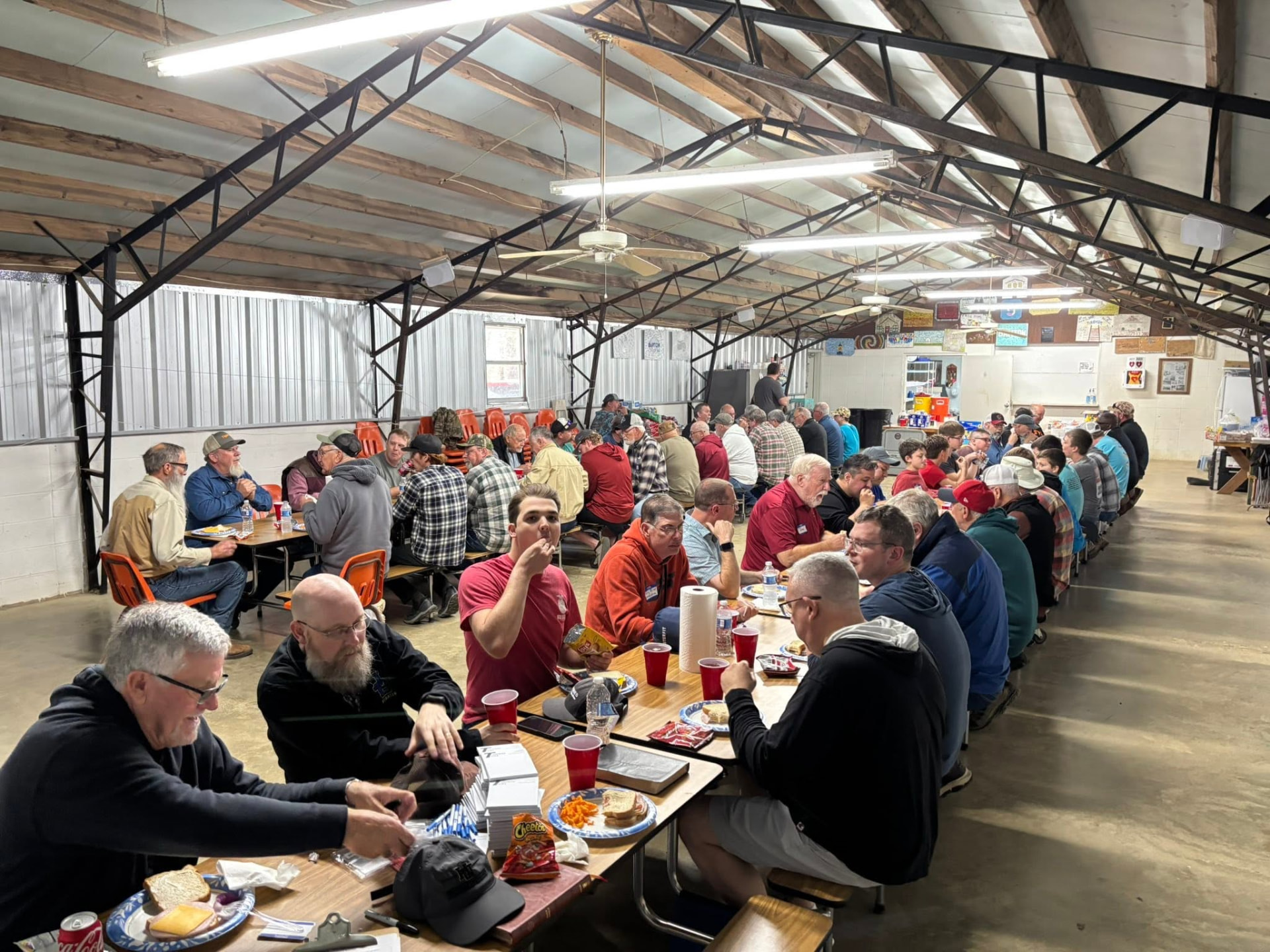 Men eating together at long tables in the camp mess hall